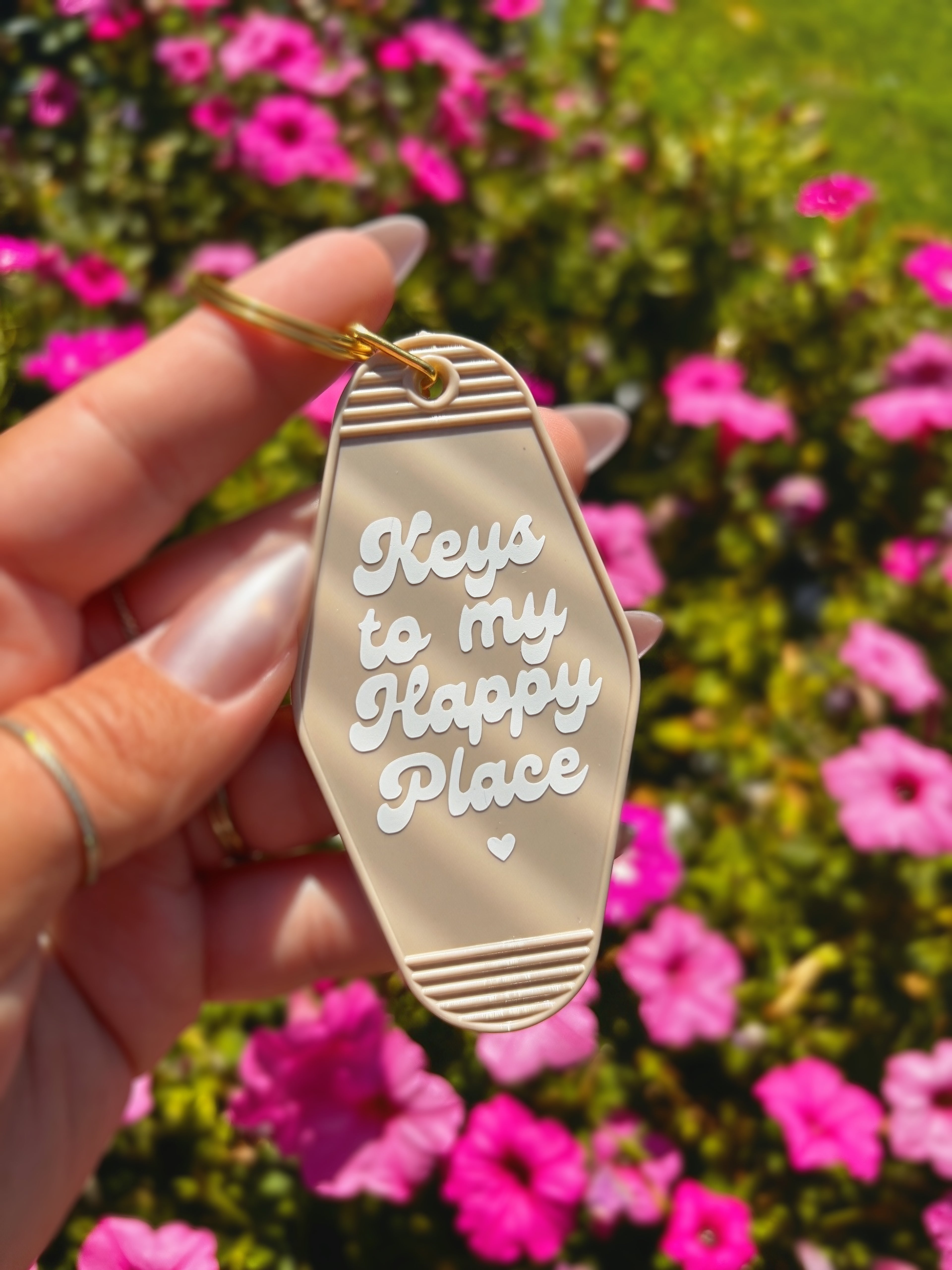 A hand holding a beige plastic keychain shaped like a shoe sole with the phrase &