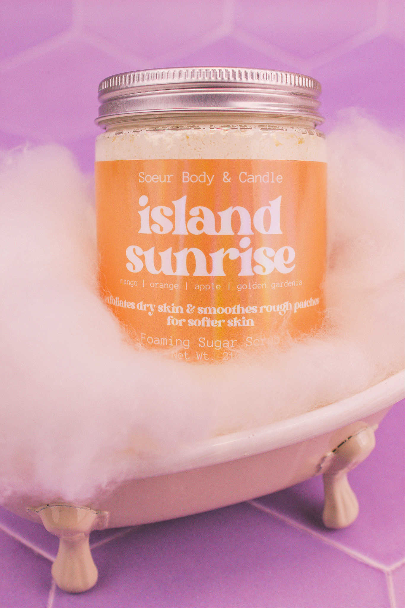 Island Sunrise sugar scrub in a small tub with fake bubbles. Notes of mango, orange, apple, and golden gardenia.