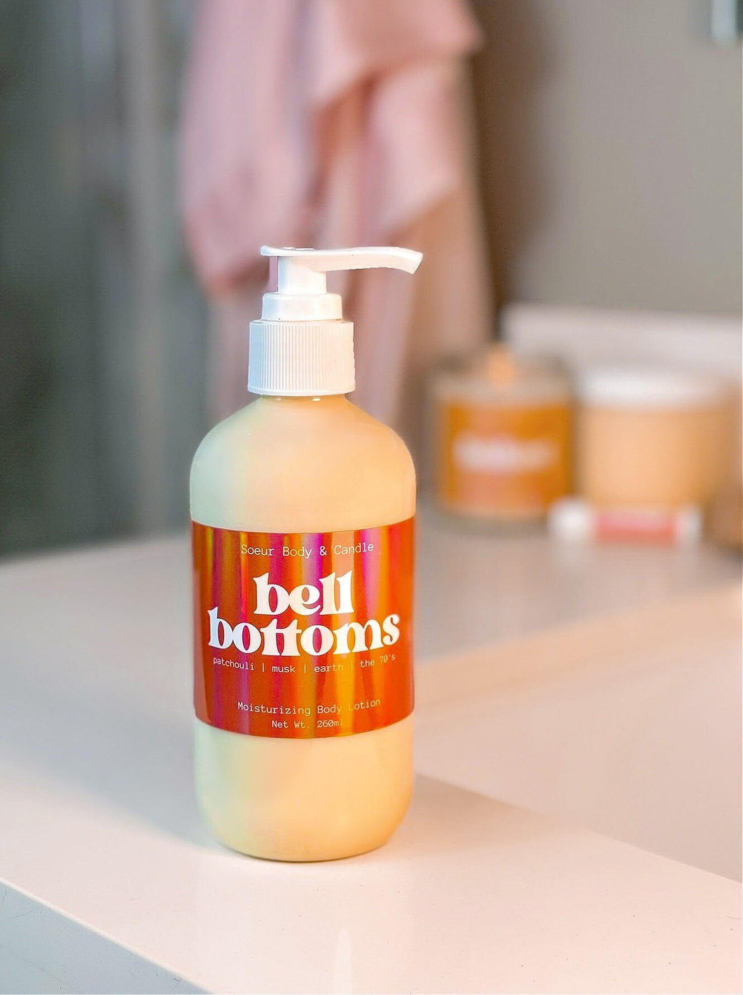 Bell Bottoms Body Lotion sitting on a bathroom counter, featuring hemp oil for moisturizing with a &