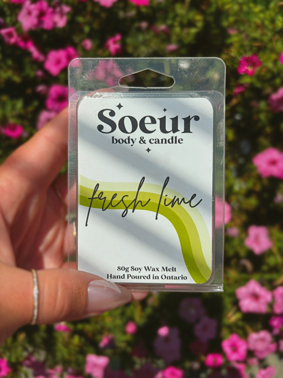 A hand holds a packaged Soeur Body &amp; Candle &