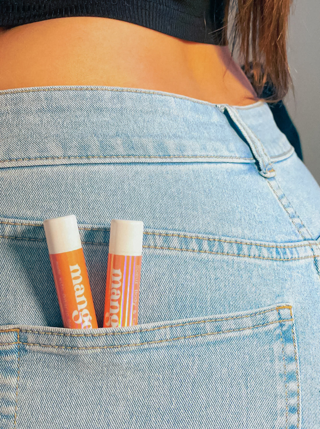 Mango lip balm in a tube, made with Ontario beeswax, coconut oil, and castor oil, offering softness and hydration.