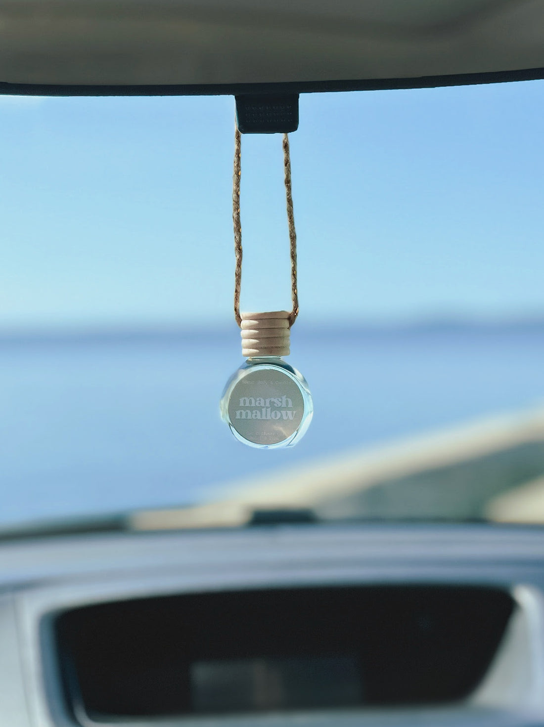 Marshmallow Diffuser Oil hanging from a rearview mirror, offering a balanced, long-lasting fragrance of marshmallow crème, vanilla, and toasted almond. Perfect for cars, closets, lockers, and more.