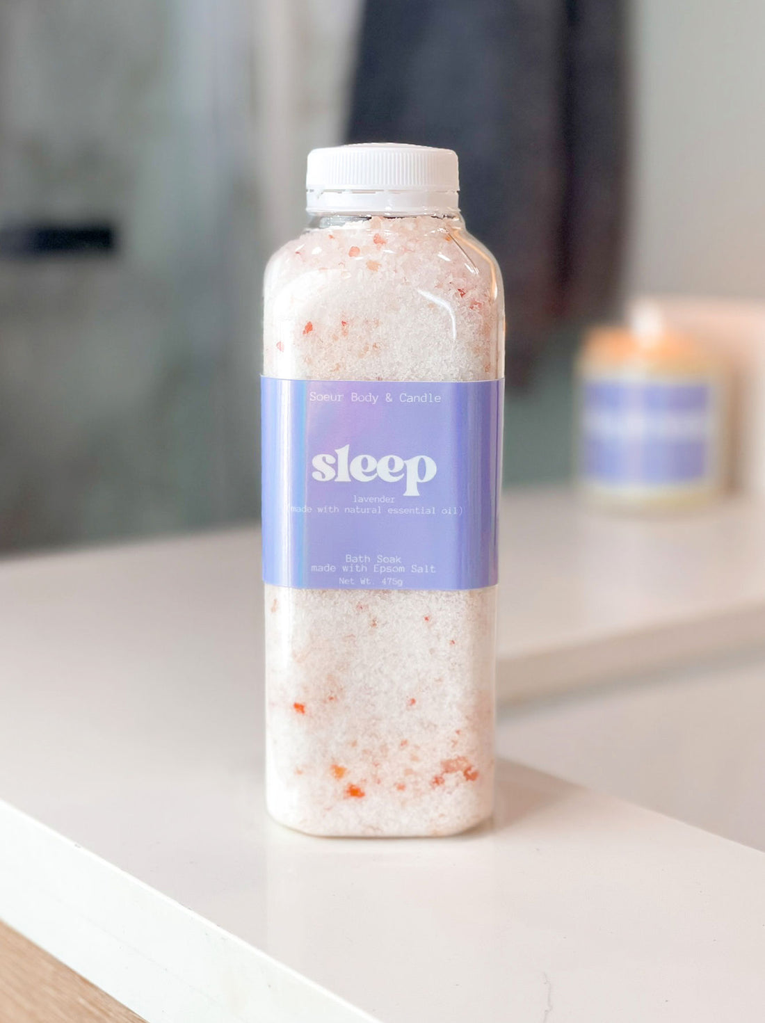 Sleep bath soak made with lavender essential oil on a bathroom counter, featuring Epsom Salt for muscle relaxation and Himalayan Pink Salt, rich in essential minerals like potassium, calcium, and magnesium.