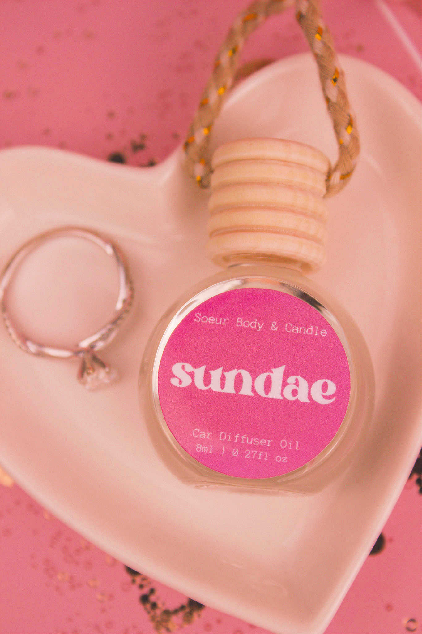 Close-up of Sundae car diffuser in a jewelry dish with a ring beside it, featuring notes of sweet cream, vanilla,  and sugary waffle cone.
