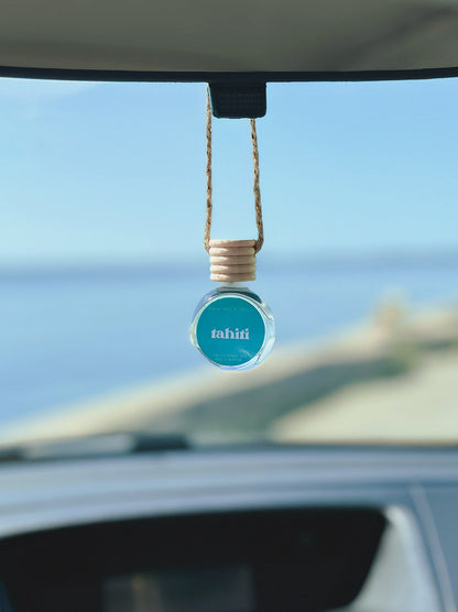 Tahiti Diffuser Oil hanging from a rearview mirror, offering a balanced, long-lasting fragrance of sugar, vanilla, almond, amber, and oak moss. Perfect for cars, closets, lockers, and more.